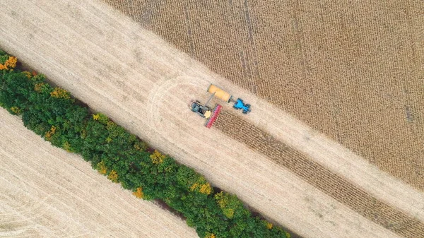 トラクタートレーラーにトウモロコシの穀物をオフロード結合の空中ビュー 農地で働く農業機械を飛び越える 収穫の概念 回転ショット — ストック写真