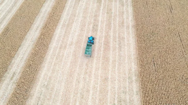 수확하는 트레일러와 들판을 이동하는 트랙터의 드론은 농지를 통과하는 기계를 합니다 — 스톡 사진