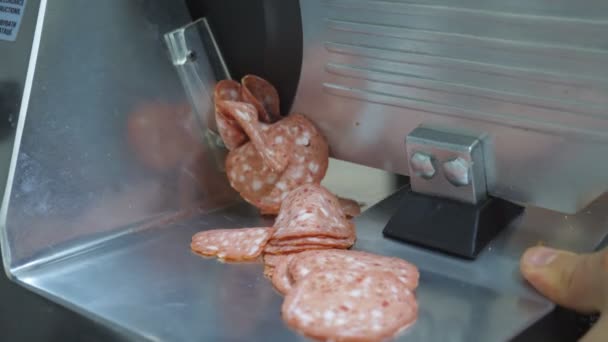 Chef picando salchichas en rebanadora de comida eléctrica en la cocina. Cocinero masculino usando máquina de cortar para salami en el restaurante de cocina. Proceso para preparar ingredientes para cocinar pizza. Primer plano: cámara lenta — Vídeo de stock