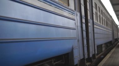 Yolcu treni bir kameranın yanından geçiyor ve istasyona varıyor. Demiryolu boyunca ilerleyen trenin dönen çelik tekerleklerini kapatın. Ulaşım ve seyahat kavramı. Düşük Görünüm Yavaşlatıcı