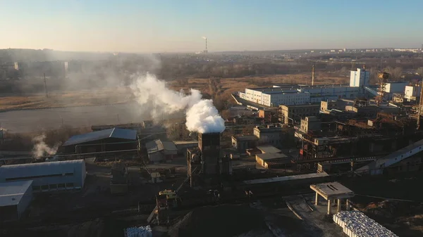 Aerial shot of smoke pouring from chemical factory into atmosphere. Flying above industrial plant emitting toxic vapor to nature. Problem of air pollution and global warming. Top view.