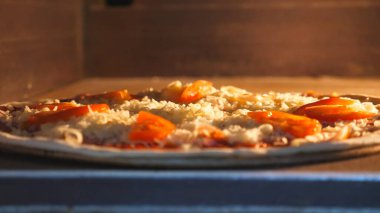 Domates ve peynirli lezzetli pizza, mutfak restoranında elektrikli fırında pişiyor. Mozzarella yüksek sıcaklıkta fırında eriyor. Yemek hazırlama süreci. Dolly vurdu..