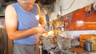 Atölyede dairesel testereli profesyonel metal işleme detayı. Garajda elektrikli öğütme tekerleği kullanarak metal kesmekte ustasın. Parlak kıvılcımlar uçuşuyor. Yavaş çekim.