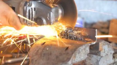Metal işlemede dairesel testere ile detaylı görüş. Profesyonel tamircinin elleri enstrüman tutuyor ve metal öğütüyor. Garajda ya da atölyede demir kesen becerikli bir tamirci. Kapat.
