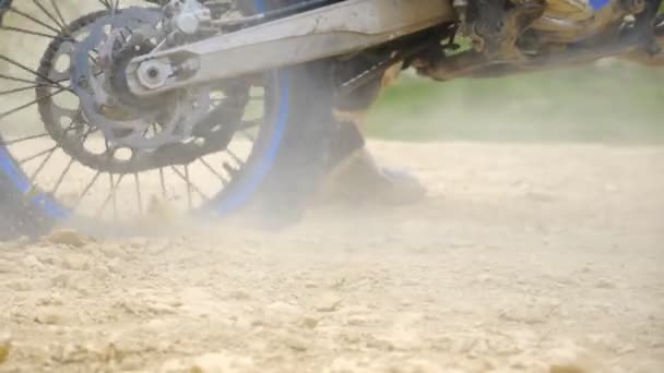 Közel kerék erős off-road motorkerékpár forog, és rugdossa fel a száraz talaj vagy por. Professzionális motoros rajtverseny. Fogalom a motorsport vagy az aktív életmód. Dolly lőtt. — Stock videók