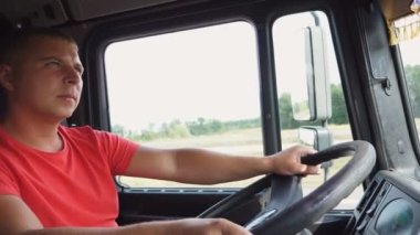 Kamyon şoförünün direksiyonda el ele tutuşup durduğu yere giden kamyonu kontrol etmesi. Taşra yolunda kamyon şoförü. Kırsal kesimde araba kullanan bir adam. Lojistik kavramı