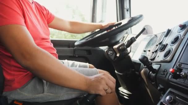 Braço masculino está mudando engrenagens na transmissão manual durante a condução de um carro. Mão de motorista de caminhão segurando um grande volante do caminhão. Camionista dirigindo para o destino na estrada de campo. Conceito logístico — Vídeo de Stock