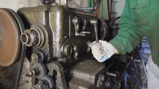 Mains masculines de mécanicien en gants travaillant sur un vieil établi dans son garage. Le réparateur utilise le tour pour transformer le métal en atelier. Travail dur sur la fraiseuse sur le lieu de travail. Gros plan Mouvement lent — Video