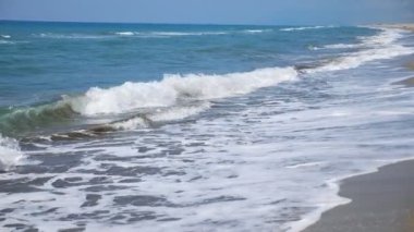 Büyük okyanus dalgalarının kıyıya vurduğu boş kumsal sahili. Tropik tatil köyünde güneşli güzel bir gün. Manzaralı deniz manzarası. Yavaş çekim