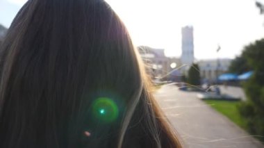 Sıcak yaz sabahında işe giden iş kadınlarının saçlarını kapat. Tanımlanamayan genç bir kız, esintinin tadını çıkarıyor. Siyah saçlı bir kadının kaldırımda yürüdüğünü gördüm. Kapat.