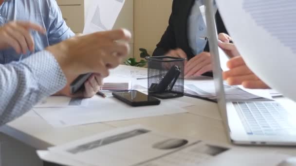 Gruppe von Arbeitnehmern, die im Büro am Tisch sitzen und effizient mit Dokumenten arbeiten. Hände von Geschäftsleuten aus dem kreativen Team beschäftigen sich mit der Entwicklung des Geschäfts. Blick auf das Arbeitschaos auf dem Schreibtisch. Zeitlupe — Stockvideo