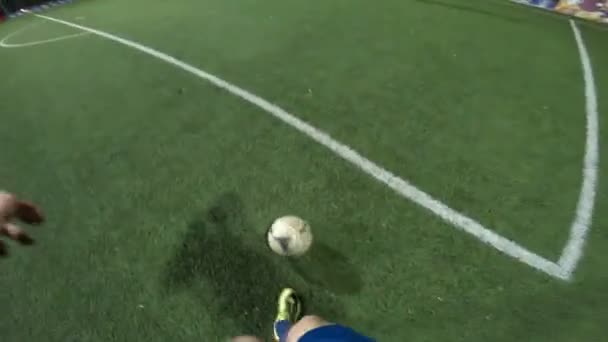 Точка зрения футболиста, тренирующего свои навыки на футбольном поле в вечернее время. Человек практикует дриблинг мяч и пинает его оппоненту. Парень передает мяч другу. Концепция отдыха. POV — стоковое видео