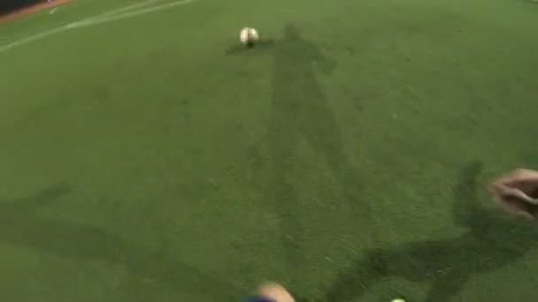 Standpunkt des Fußballers, der abends auf dem Fußballplatz seine Fähigkeiten trainiert. Mann übt, den Ball zu dribbeln und ihn zum Gegner zu treten. Guy gibt den Ball an Freund weiter. Freizeitkonzept. POV — Stockvideo