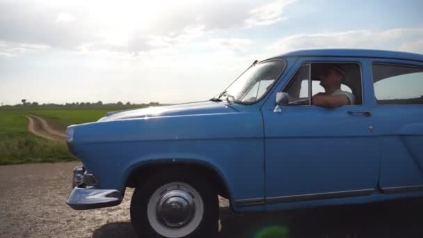 Carro velho clássico que viaja na estrada no dia chuvoso do verão. Casal jovem dirigindo na estrada rural em automóvel vintage. Viagem no retro auto. Conceito de férias de verão ou férias. Lento movimento Closeup — Vídeo de Stock