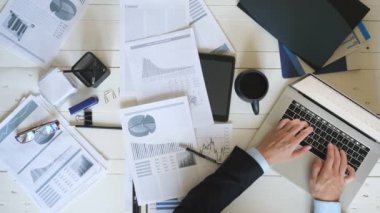 Genç girişimcilerin beyaz masadaki dizüstü bilgisayarda klavyeyle yazı yazan üst düzey yöneticileri. Başarılı bir iş adamı gözlük takar ve grafikleri istatistiklerle analiz eder. Yavaş çekim