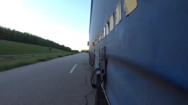 Otoyolda kamyon sürüyor. Kamyon kırsaldan geçiyor. Traktör römorkundan asfalt yola giden araba trafiğine bakış açısı. Taşımacılık ve ticari araç kavramı. Zaman Süreleri