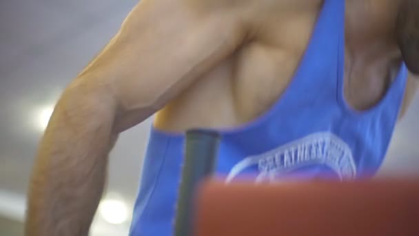 근육질 운동 선수의 남자 손에 근접 해서 체육 클럽에서 불균등한 바에 힘을 주고 있습니다. 운동복을 입은 건장 한 남자 가 실내에서 힘든 운동을 하고 있어요. 건강하고 활동적 인 생활 방식의 개념. 느린 동작 — 비디오