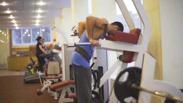 Pria yang kuat melakukan push up dengan berat pada bar yang tidak rata di gym. Muda atlet otot dalam pakaian olahraga melakukan latihan keras di dalam ruangan. Konsep hidup sehat dan aktif. Tutup Lambat gerak — Stok Video