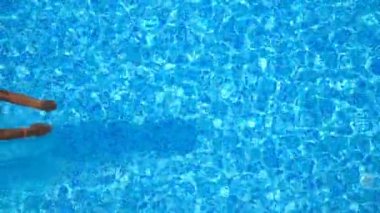 Havuza atlayan ve kristal berrak su sıçratan genç adamın en iyi görüntüsü. Güneşli bir günde havuzda su altında yüzen tanınmayan bir adam. Yaz tatilinde dinlenen bir adam. Yavaş çekim. Yakın çekim.