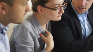 Profesyonel yöneticiler takım toplantısında satış sonuçlarıyla birlikte çizelgeleri analiz ediyorlar. Masada oturan gelir grafiklerini inceleyen genç meslektaşlar. İş arkadaşları mali raporları kontrol ediyor. Turna atışı