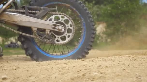 Cerca de la rueda de la motocicleta todoterreno de gran alcance girando y pateando el suelo seco. Carrera o entrenamiento profesional de motocross rider. Concepto de estilo de vida activo. Vista lateral Cámara lenta — Vídeos de Stock