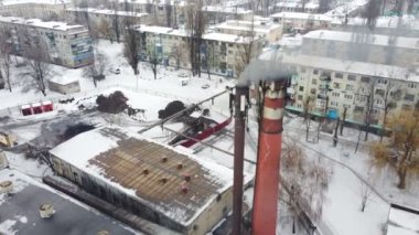 Endüstriyel girişim borusundan hava dumanı yükseliyor. Kentsel fabrikanın üzerinde uçan insansız hava aracı atmosfere zehirli buhar yayıyor. Üretim ve hava kirliliği kavramı. Üst Görünüm Kapat