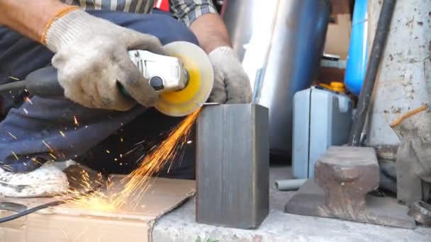 Primer plano en el procesamiento de metales con sierra circular y chispas brillantes volando alrededor. Molienda mecánica de metal con sierra circular. Trabajador de corte detalle de hierro en garaje o taller. Movimiento lento — Vídeos de Stock