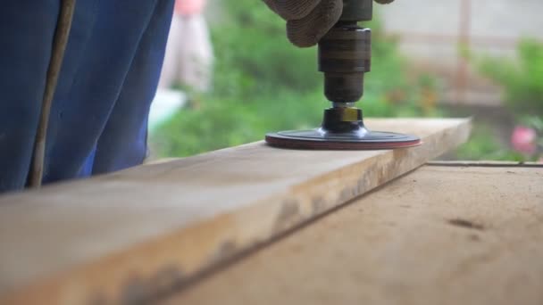 Närbild av träbearbetning. Oigenkännlig snickare som arbetar i sin verkstad. Artisan bearbetning arbetsstycke för någon träprodukt. suddig bakgrund med sågspån flyger runt. Långsam rörelse Låg sikt — Stockvideo