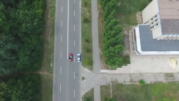 Aerial shot of red convertible car riding through countryside road. Young couple traveling at cabriolet. Happy just married pair enjoying journey. Flying over auto driving on highway. Travel concept — Stock Video