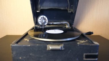 Gramofon çalan eski modelin ön görüntüsü. Şırınga siyah vinil plakta kolayca kayıyor ve vintage turntable 'da dönüyor. Retro konsept. Yavaş çekim. Yakın çekim.