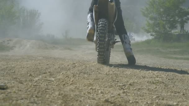 Pembalap Motocross mulai mengendarai motornya yang kotor menendang tanah dan debu. Tampilan belakang Gerakan pelan — Stok Video