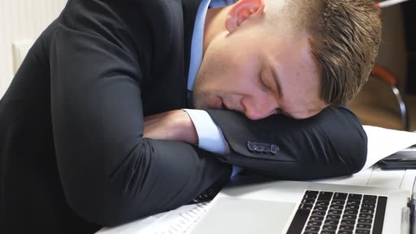 Cerca de jefe exhausto en traje formal que se queda dormido en la mesa en la oficina. Joven emprendedor durmiendo en el escritorio con portátil en la sala de juntas. Gerente cansado durmiendo en el lugar de trabajo. Movimiento lento — Vídeo de stock