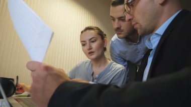 Profesyonel yöneticiler takım toplantısında satış sonuçlarıyla birlikte çizelgeleri inceliyor. Genç meslektaşlarım masada oturan gelir grafiklerini analiz ediyorlar. İş arkadaşları içeriden mali raporları kontrol ediyor. Düşük görünüm