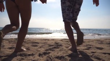 Genç mutlu çift sahilde koşuyor ve el ele tutuşuyorlar. Erkek ve kadın gün doğumunda kıyıya doğru koşuyorlar. Kız ve erkek yaz tatilinde birlikte eğleniyorlar. Yavaş çekim