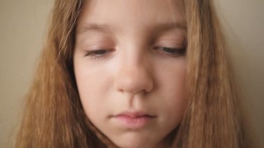 Kapalı bir yere bakan çaresiz bir çocuğun kadın yüzünü kapatın. İçinde hüzünlü bir ifade olan küçük sarışın kızın portresi. Üzgün küçük çocuğun hayal kırıklığına uğramış bakışları.