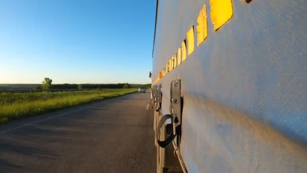 Camion avec marchandises conduisant sur route asphaltée. Point de vue du côté à la remorque de camion se déplaçant à travers la campagne. Voiture commerciale à destination. Concept de transport de marchandises. Délai imparti — Video