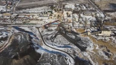Kış günü fosil çıkarmak için fabrikanın hava görüntüsü. Endüstriyel madencilik kuyusunda uçan insansız hava aracı. Ekoloji ve çevre kirliliği sorunu. Üretim ve üretim kavramı