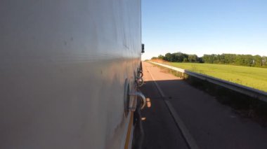Kırsal bölgede hareket eden bir kamyon römorkundan diğerine. Yaz günü asfalt yolda mal taşıyan bir kamyon. Hedefe giden ticari bir araba. Kargo taşımacılığı kavramı. Yavaş çekim