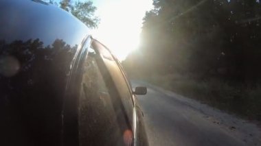 Güneşli bir yaz gününde otoyolda giden bir arabanın plakasından. Siyah otomobil güzel manzaralı otobanda ilerliyor. Otomobil taşra yolunda yol alıyor. Yolculuk kavramı