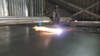Metal plakadan plazma kesimi. Çelik bir levhadan çalışma malzemesi üretmek. Lazer kesici çalışıyor. Endüstriyel metal üretimi. Atölyede detayları anlatıyorum. Yavaşça kapat.
