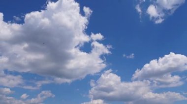 Expansive blue sky with fluffy white clouds, illustrating the gradual movement and transformation of cloud formations, evoking a sense of tranquility and natural beauty