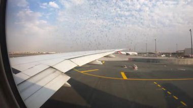 Airplane wing gliding smoothly over airport runway, showcasing terminal buildings and taxiways, capturing the anticipation of landing and the vibrant atmosphere of air travel.