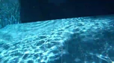 Underwater scene features hand reaching towards the surface, with bubbles rising and light reflecting off the water, creating a serene atmosphere of exploration