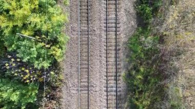 Canlı yeşilliklerle çevrili demiryolu raylarının havadan görünüşü, doğal güzelliği ve sükuneti gözler önüne seriyor, kamera manzaranın daha fazlasını gözler önüne sermek için pürüzsüz bir zoom yapıyor.