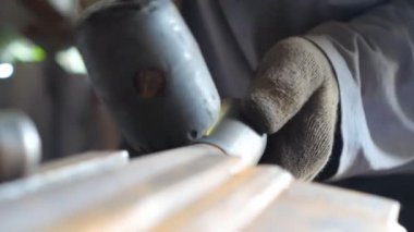 Demirci demirinin çekiç kullanarak demir işleme detaylarını kapatın. Metalle çalışan eldivenli yetişkin bir adam. Tamirci ya da tamirci dışarıda çalışıyor. Yavaş çekim Ayrıntılı görünüm.