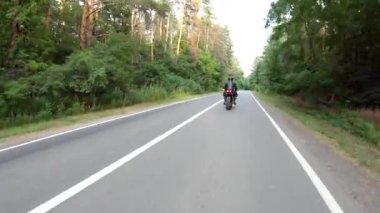 Motosikletli, ormanda araba gezisi sırasında motosiklet sürüyor. Orman yolunda, modern spor motosikletli bir adam. Motosikletli kırsal yolda bisikletiyle yarışıyor. Macera kavramı. Hava görüntüsü.