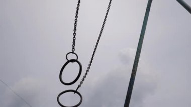 Oyun alanındaki yapıdan askıya alınmış sallanan halkalar, dinamik bir dizilimle çevrenin hareketini ve etkileşimini gösteriyor, neşeli enerji ve özgürlüğü vurguluyor..