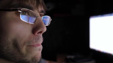 Esmer bir çalışma alanındaki bilgisayar ekranında pazar verilerini gözlemlerken derin odaklanma ve kararlılık gösteren kripto para birimi analizine daldırılmış tüccar