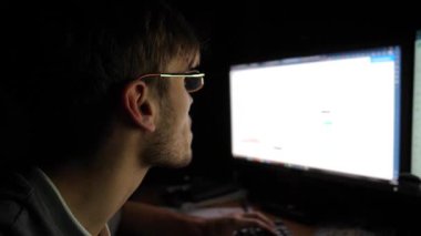 Bilgisayar ekranında kripto para piyasası eğilimlerini analiz eden odaklanmış tüccar, yumuşak monitör ışığı ile aydınlatılmış, yoğun konsantrasyon ve karanlık ortamda stratejik karar verme sürecini gösteriyor.