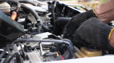 Profesyonel tamirci kolları iş yerindeki oto tamircisinin klimasını tamir ediyor. Aracın kaputu altında çalışan tamircinin erkek elleri. Bakım ve otomobil kontrolü kavramı. Yavaş çekim.